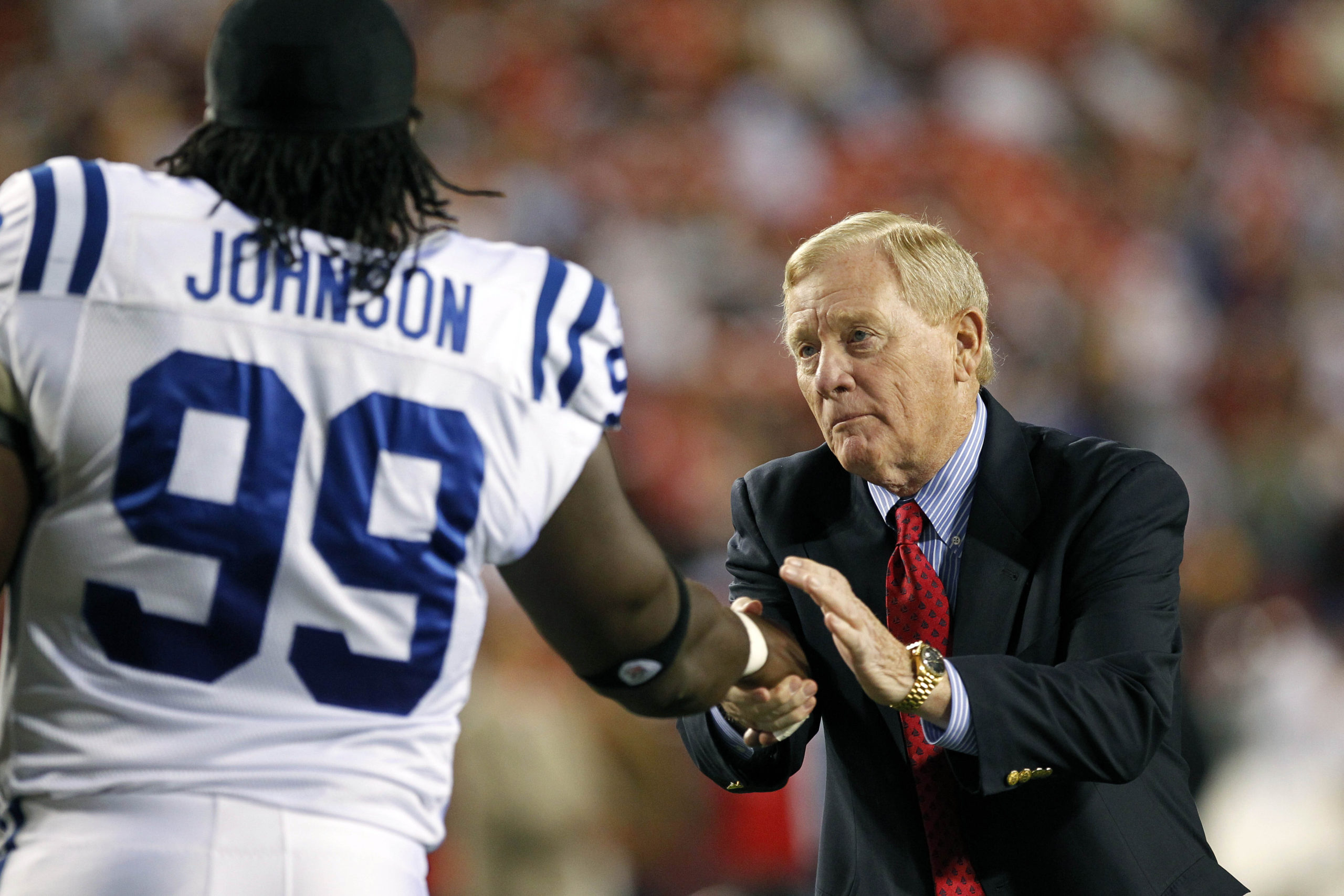 Bill Polian shaking hands with Colts player.