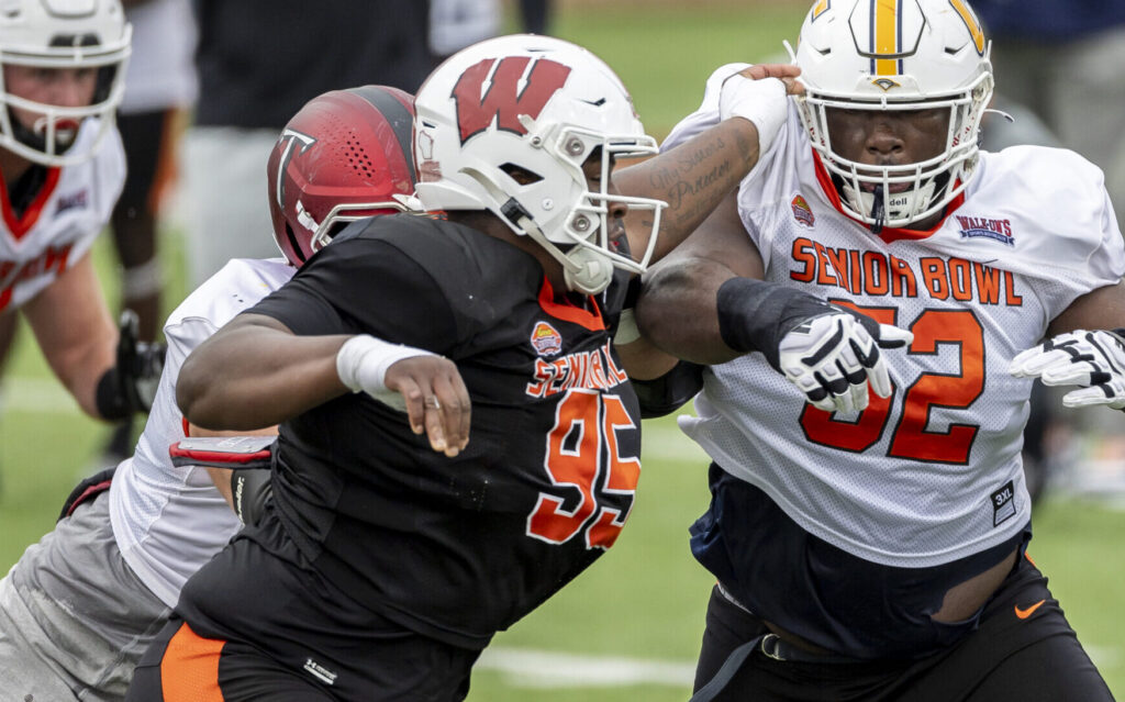 Feb 1, 2023; Mobile, AL, USA; National defensive lineman Keeanu Benton of Wisconsin (95) battles National offensive lineman McClendon Curtis of UT-Chattanooga (52) during the second day of Senior Bowl week at Hancock Whitney Stadium in Mobile. Mandatory Credit: Vasha Hunt-USA TODAY Sports