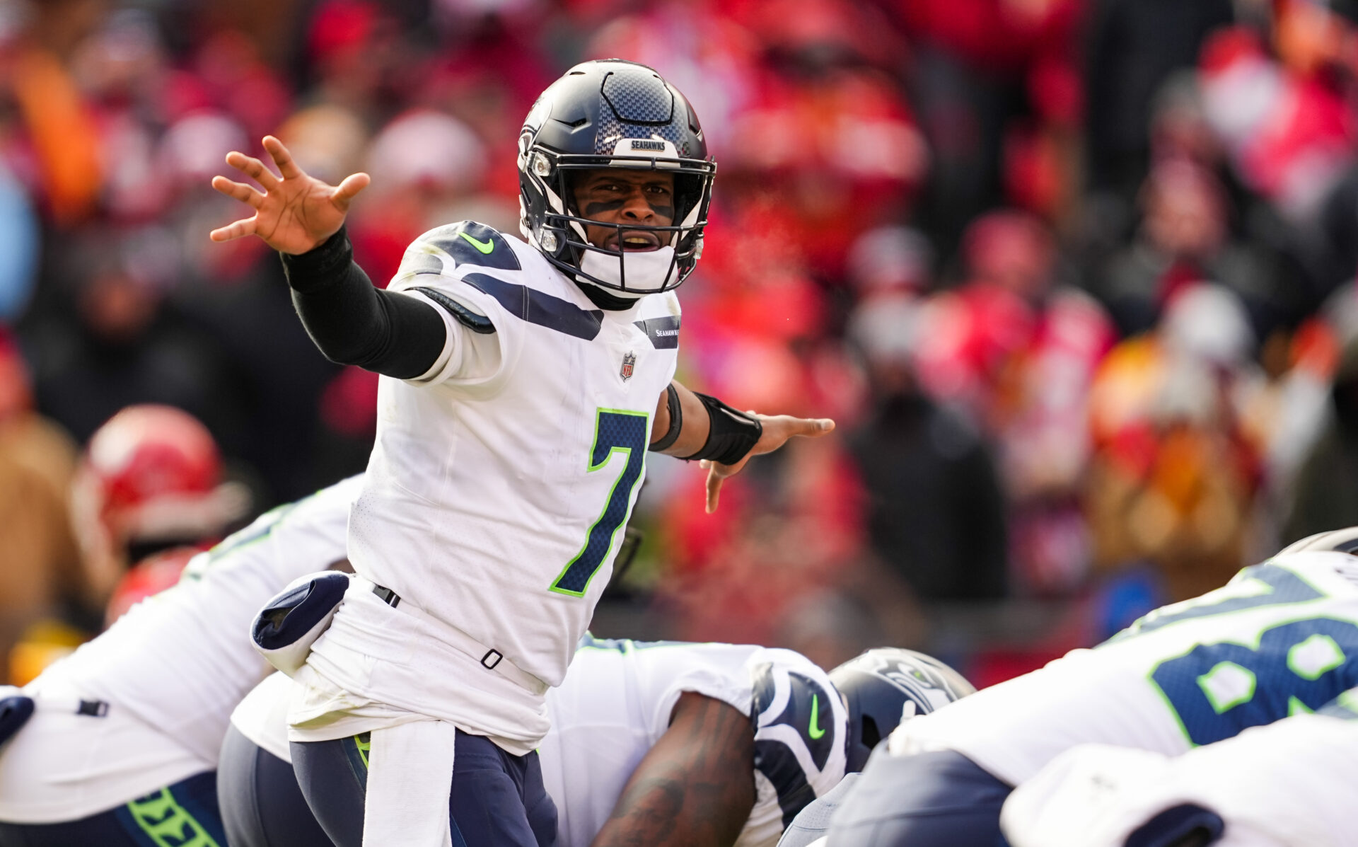 Geno Smith signals to the offense. He's wearing a white jersey and dark helmet.