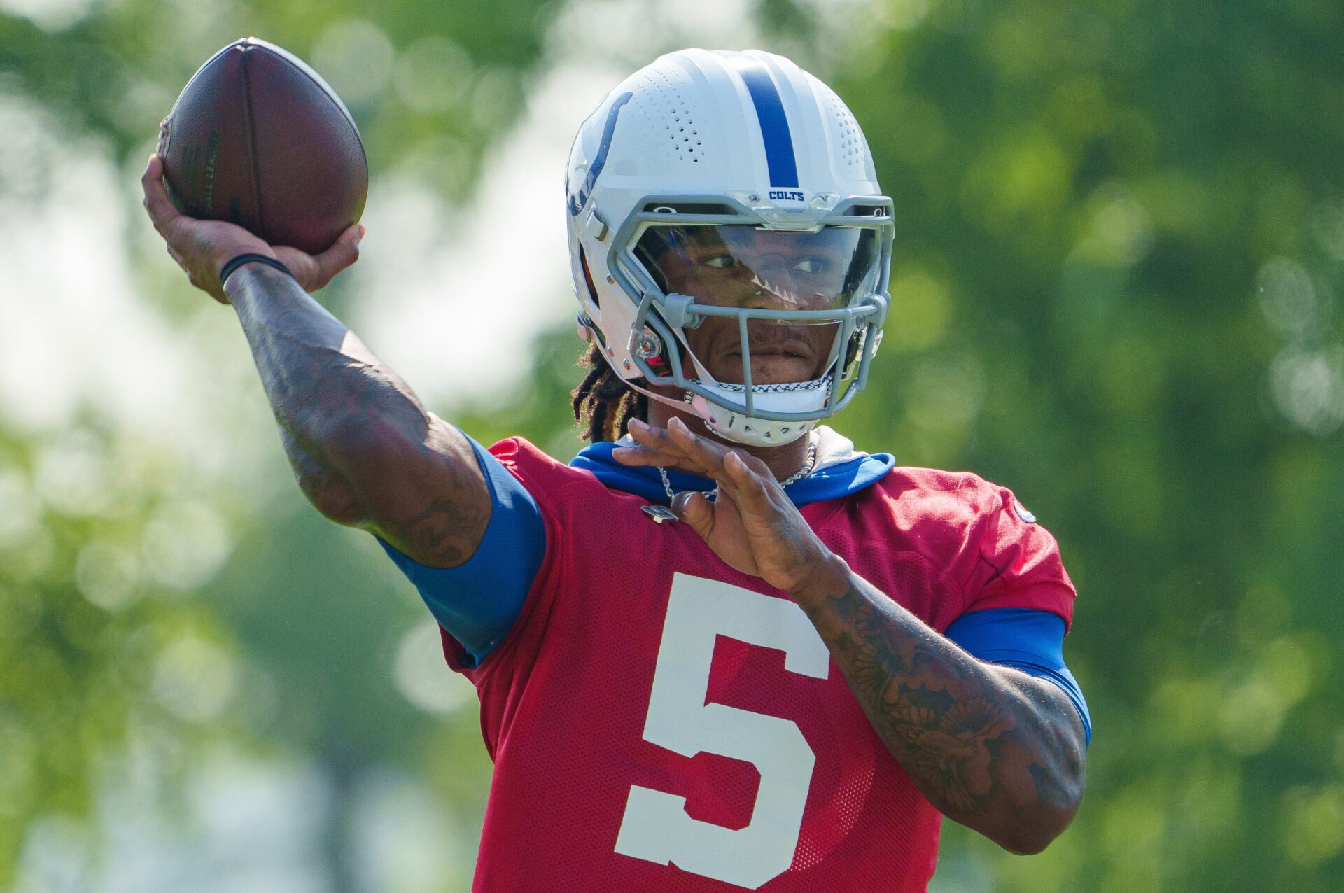 A close-up image of Indianapolis quarterback Anthony Richardson throwing a ball in a red shirt over his blue jersey