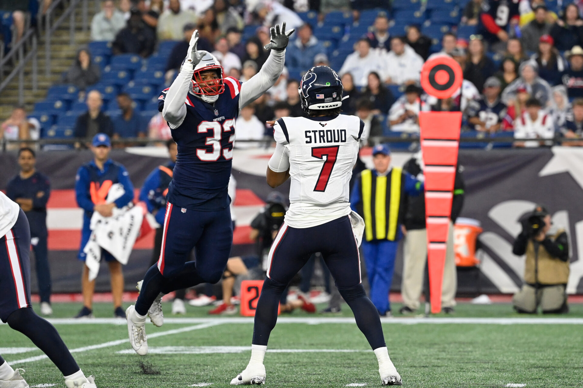 C.J. Stroud tries to throw a pass as a Patriots defender jumps into the air to try to block the pass