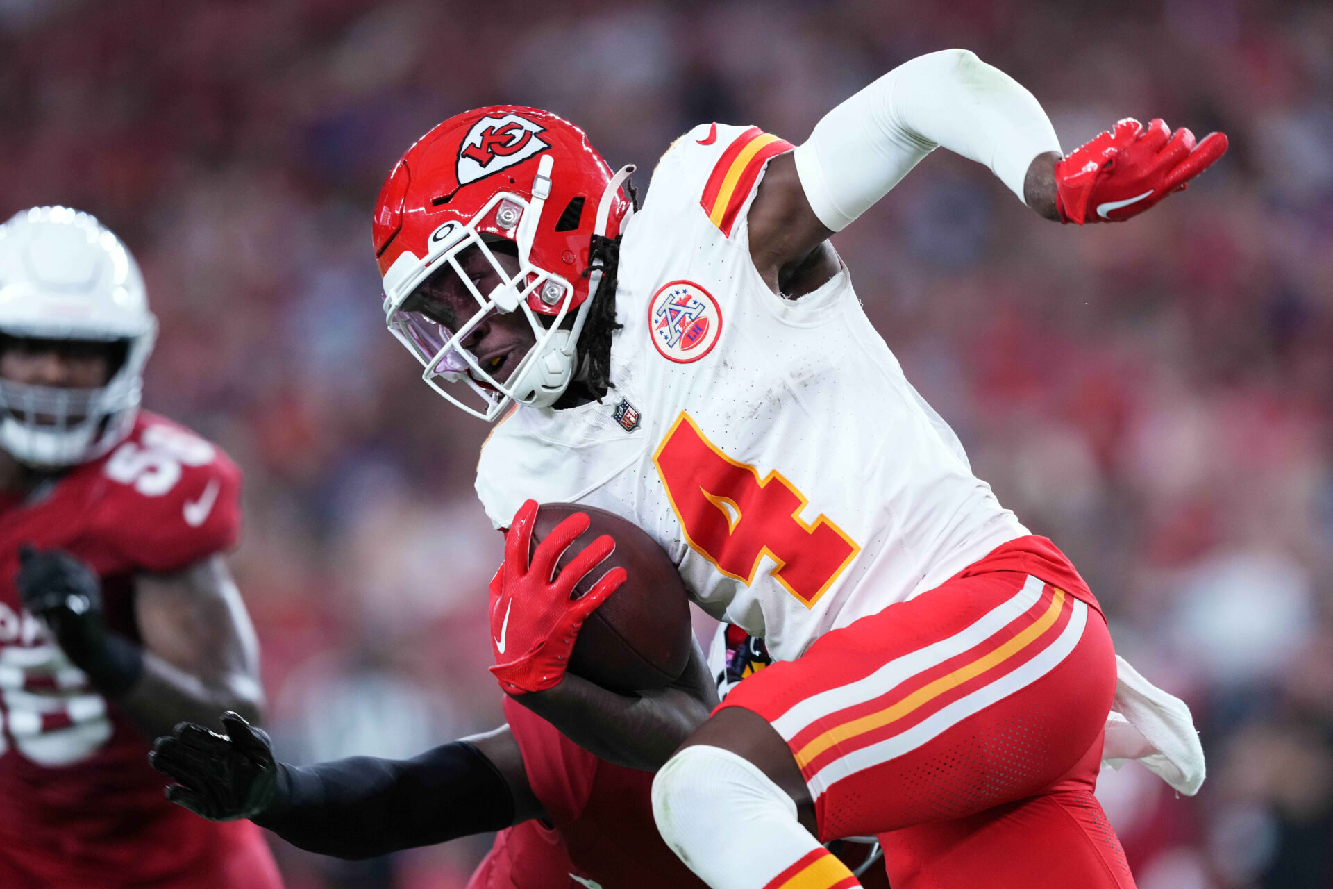 A close-up shot of Rashee Rice (in a red helmet, white jersey and red pants) running