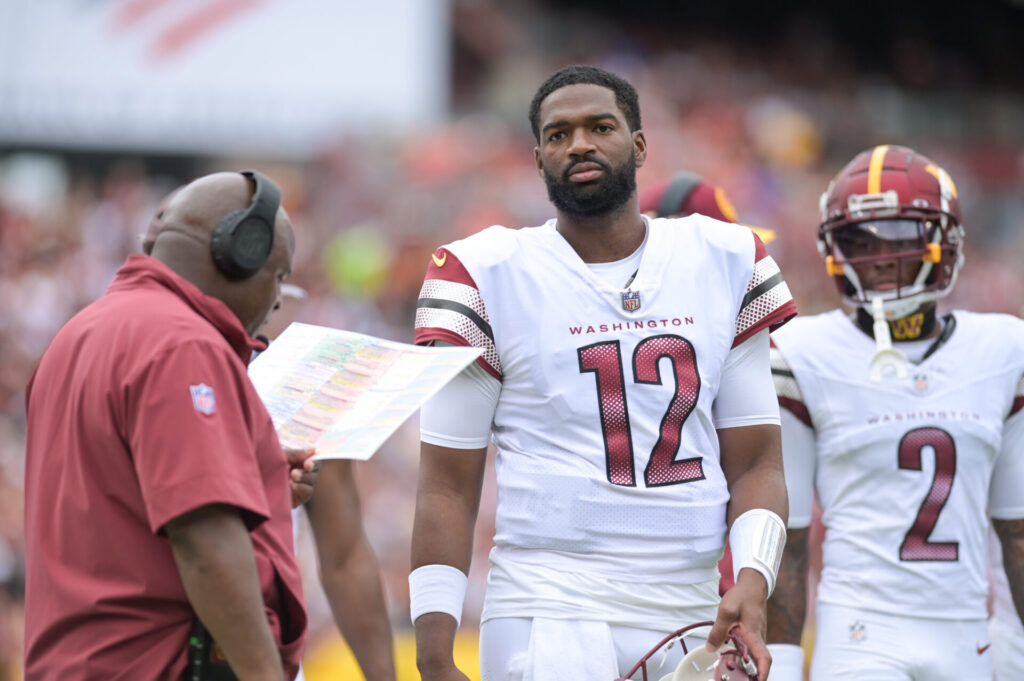 Sep 10, 2023; Landover, Maryland, USA; Washington Commanders quarterback Jacoby Brissett (12) stands with assistant head coach/offensive coordinator Eric Bieniemy during the first half Arizona Cardinals at FedExField. Mandatory Credit: Tommy Gilligan-USA TODAY Sports