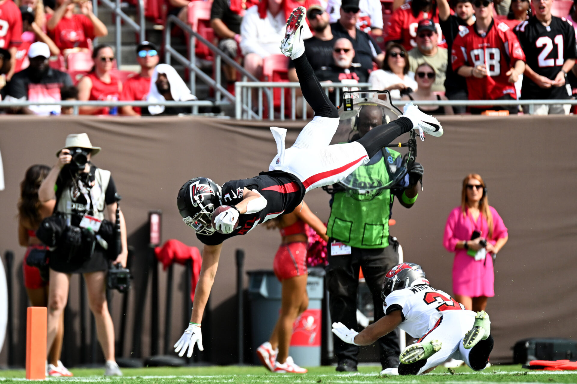 Drake London is almost horizontal in the air jumping over Antoine Winfield Jr.