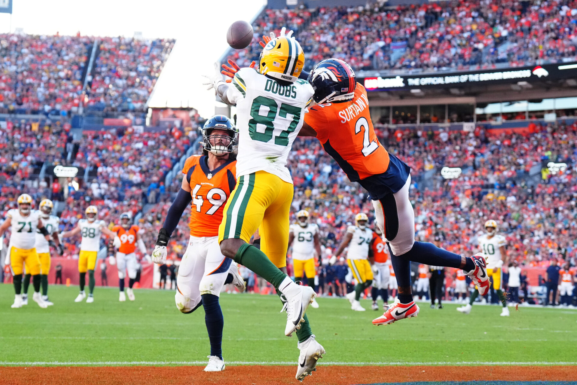 Romeo Doubs pulls in a touchdown despite two Broncos defenders near him