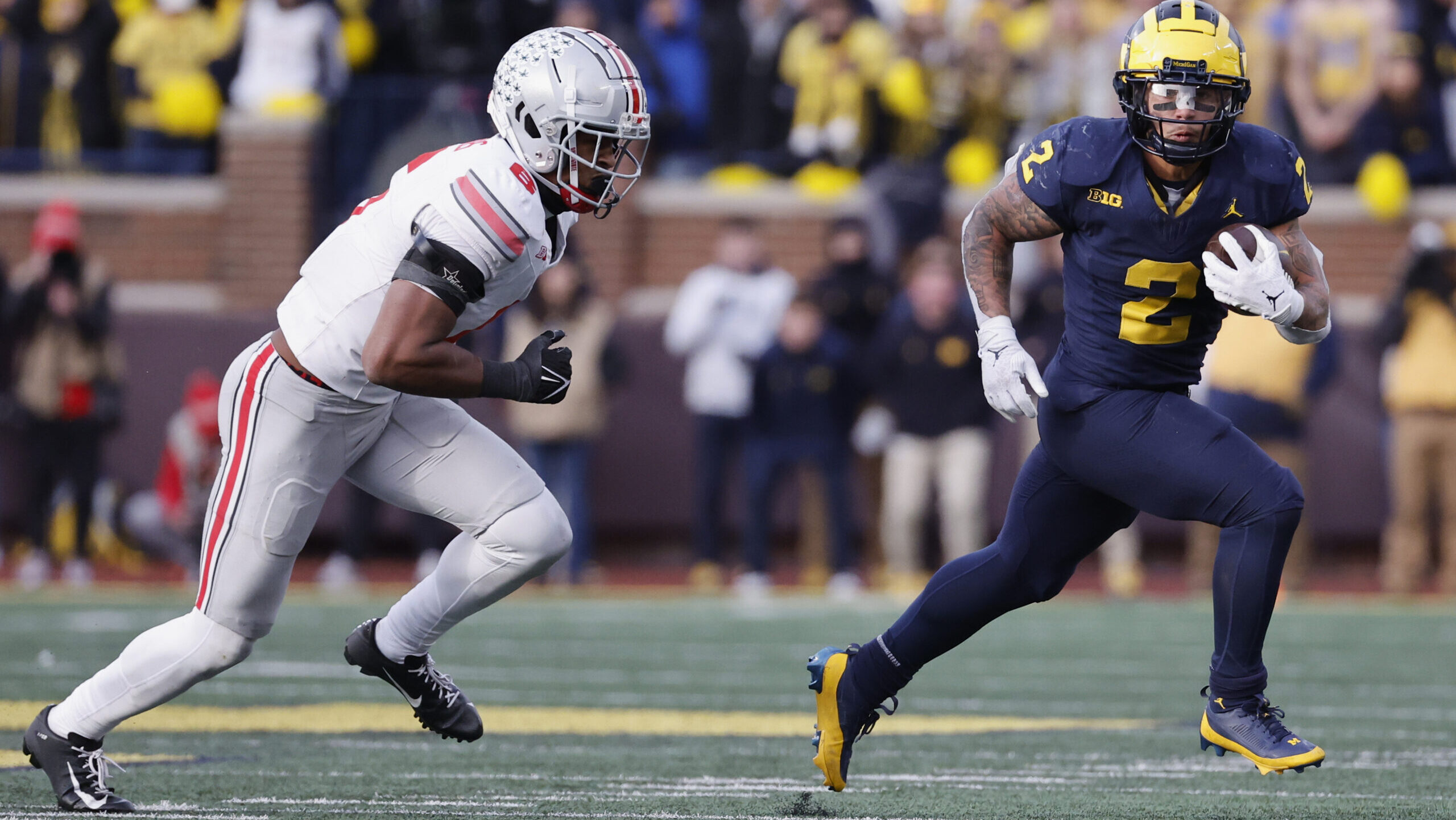 Blake Corum runs away from Ohio State defender.