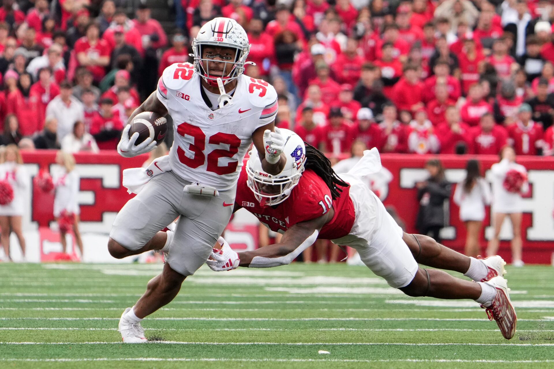 Nov 4, 2023; Piscataway, New Jersey, USA; Ohio State Buckeyes running back TreVeyon Henderson (32) runs through Rutgers Scarlet Knights defensive back Flip Dixon (10) during the second half of the NCAA football game at SHI Stadium. Ohio State won 35-16.