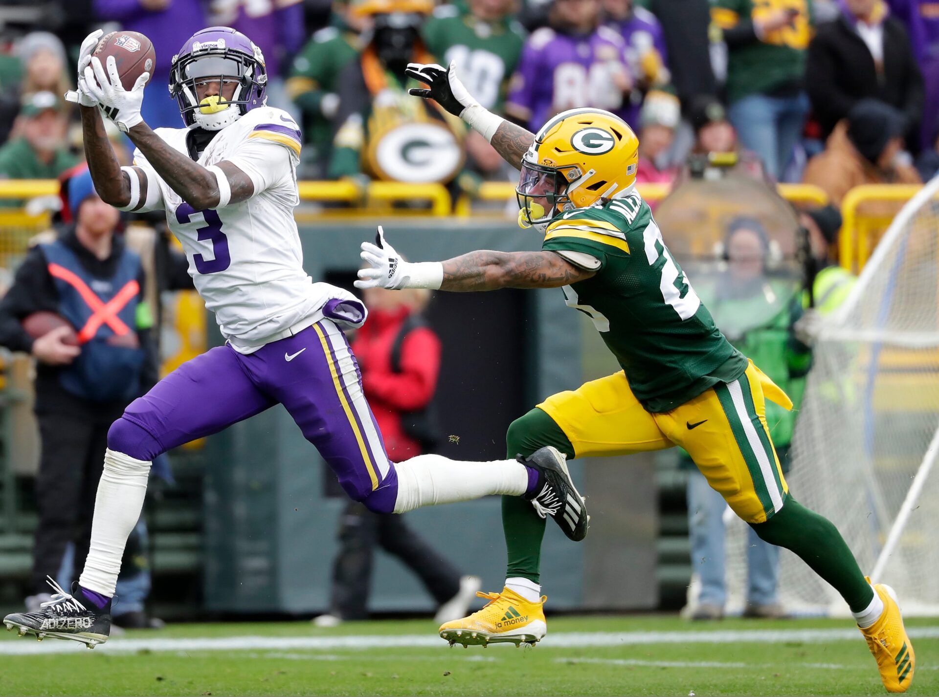Jordan Addison reaches out to make a catch with a Packers defender trailing