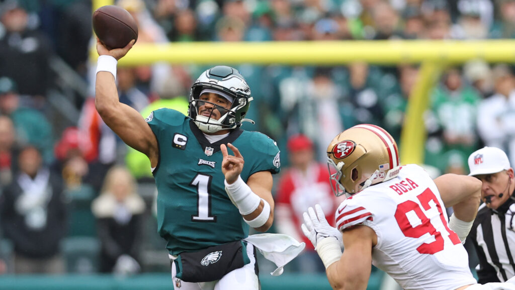 Philadelphia Eagles QB Jalen Hurts throws under pressure from San Francisco 49ers rusher Nick Bosa.