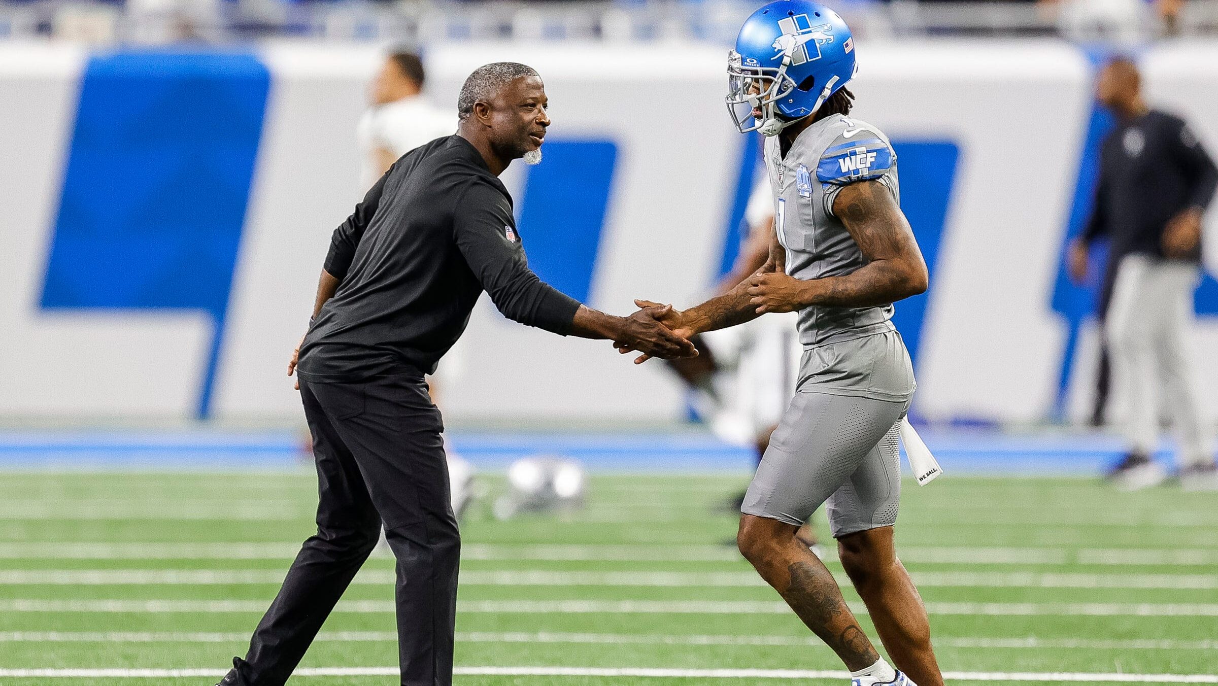 Aaron Glenn shakes Cam Sutton's hand