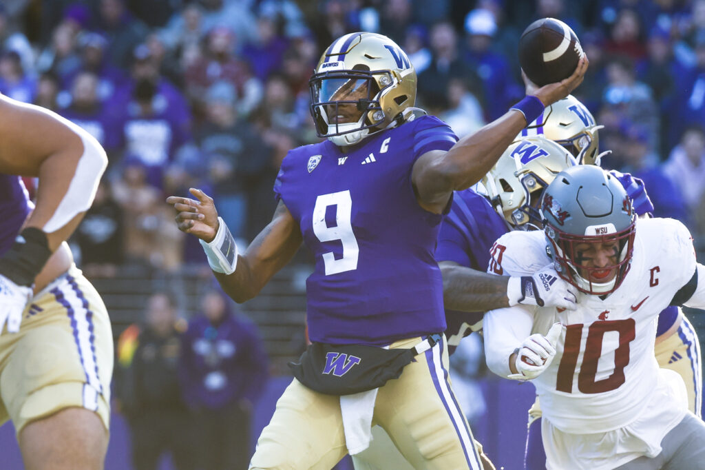 Michael Penix Jr. throws the ball during a game against Washington State as defenders close in around him