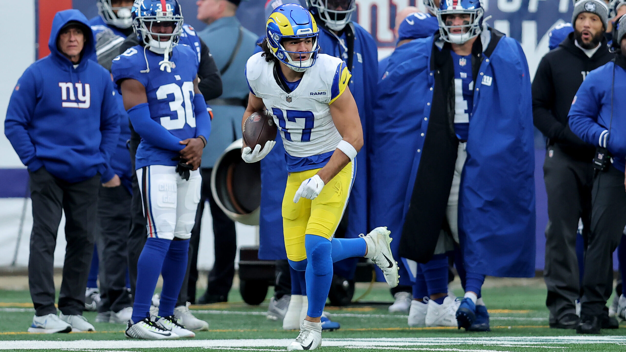 Puka Nacua runs away from Giants defenders.