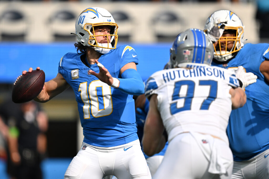 Justin Herbert, in a powder blue uniform, looks to throw in the face of pressure