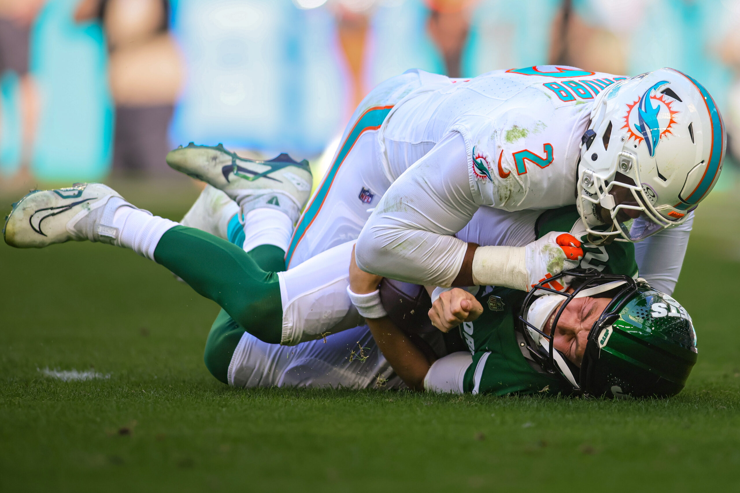 Zach Wilson on the ground with a Dolphins linebacker on top of him