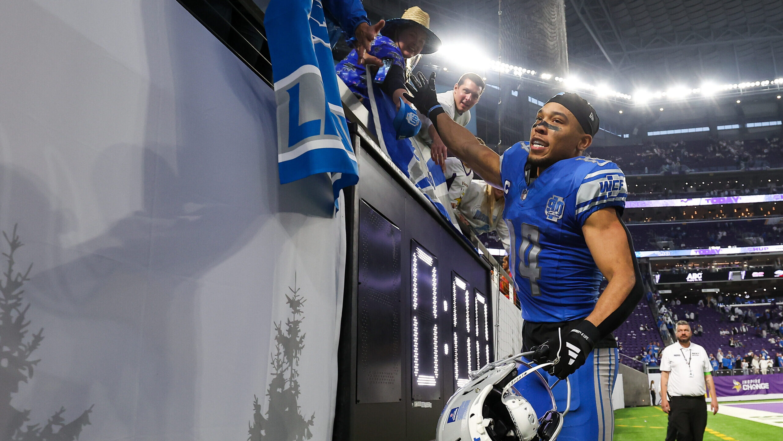 Amon-Ra St. Brown high fives Lions fans.