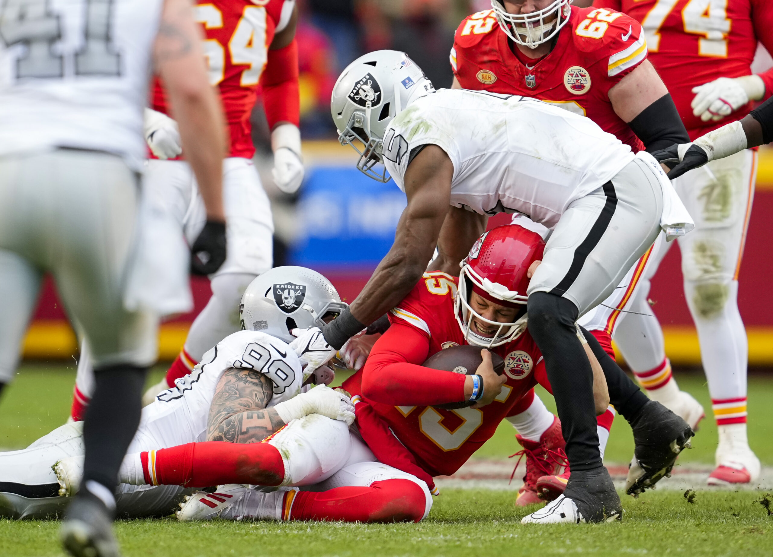 Patrick Mahomes is tackled by two Raiders players