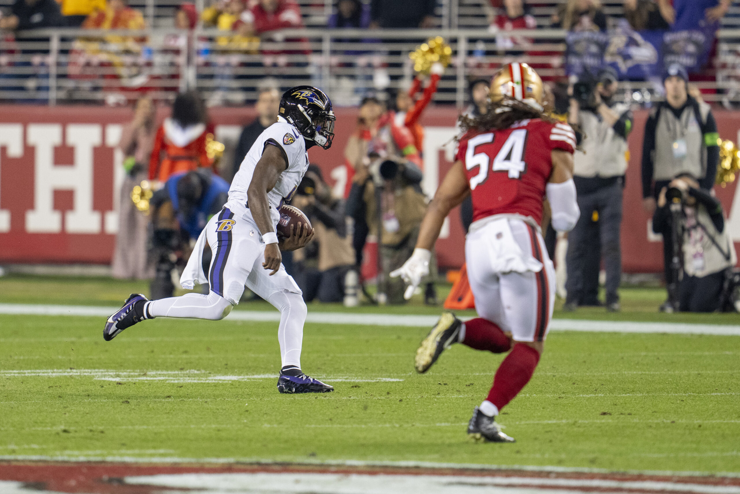 Lamar Jackson runs while Fred Warner looms