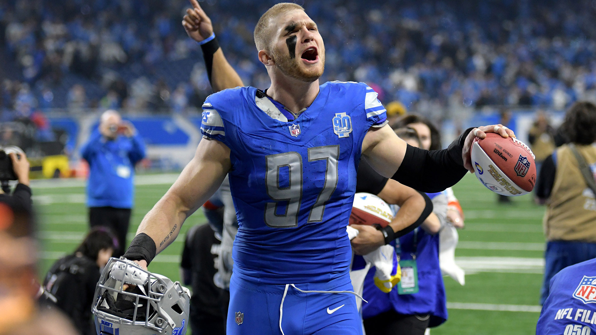 Aidan Hutchinson celebrates without his helmet on