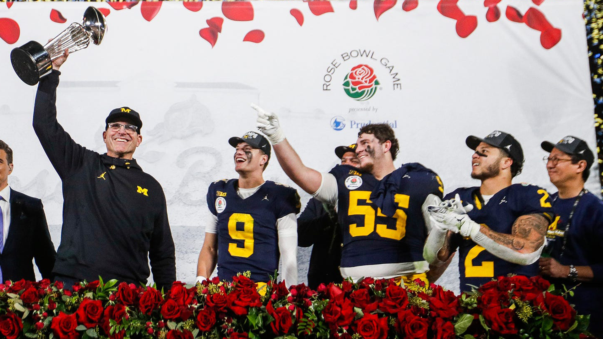 Jim Harbaugh holds up Rose Bowl trophy.