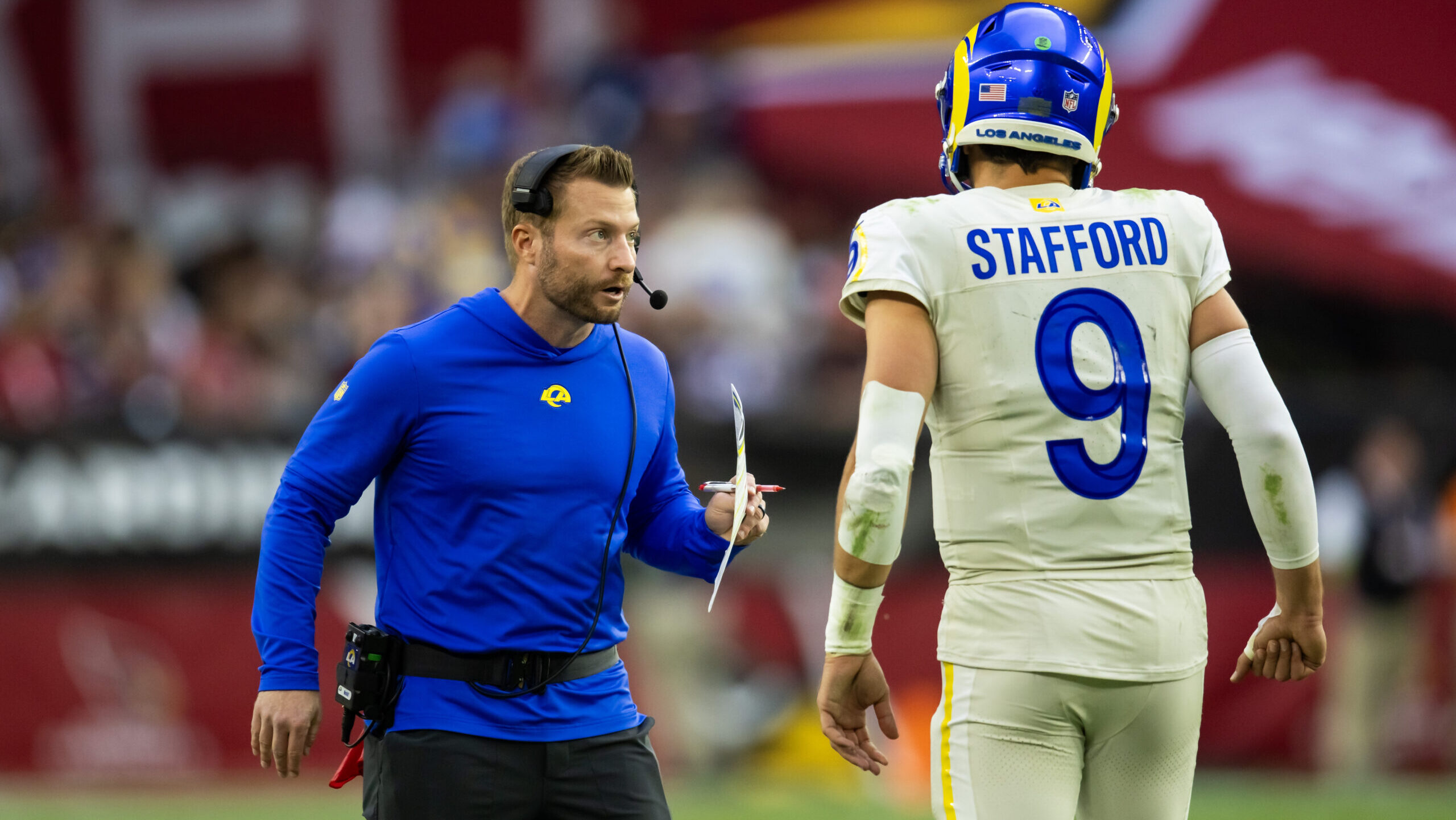 Matthew Stafford jogs off the field to speak with head coach Sean McVay