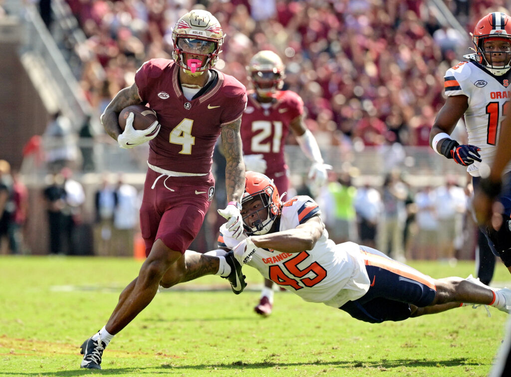 Keon Coleman evades a defender while running with the ball