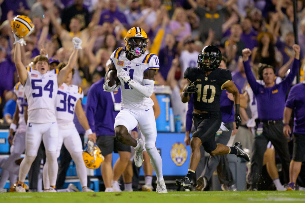 Brian Thomas Jr. runs along the LSU sideline where teammates are celebrating