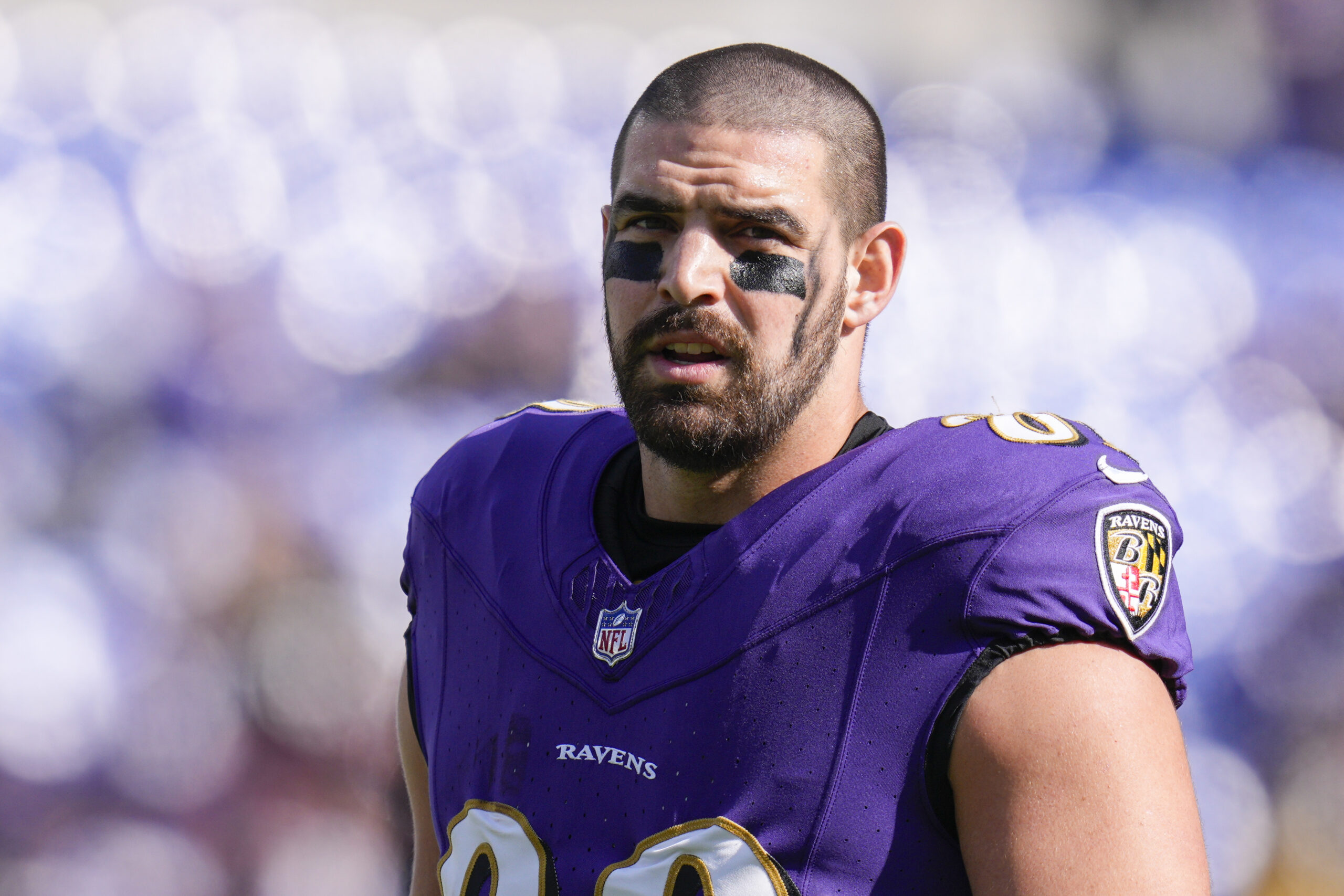 Baltimore Ravens' tight end Mark Andrews stands on the field with his helmet off
