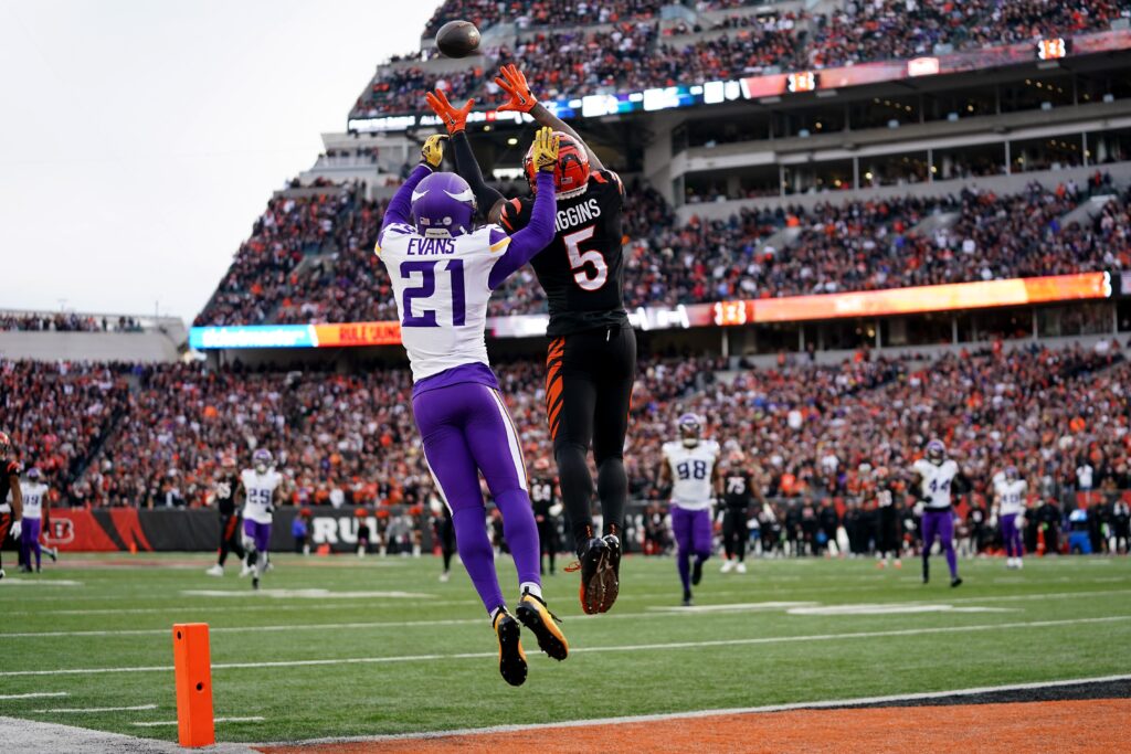 Higgins leaps up in the end zone with a Vikings cornerback behind him
