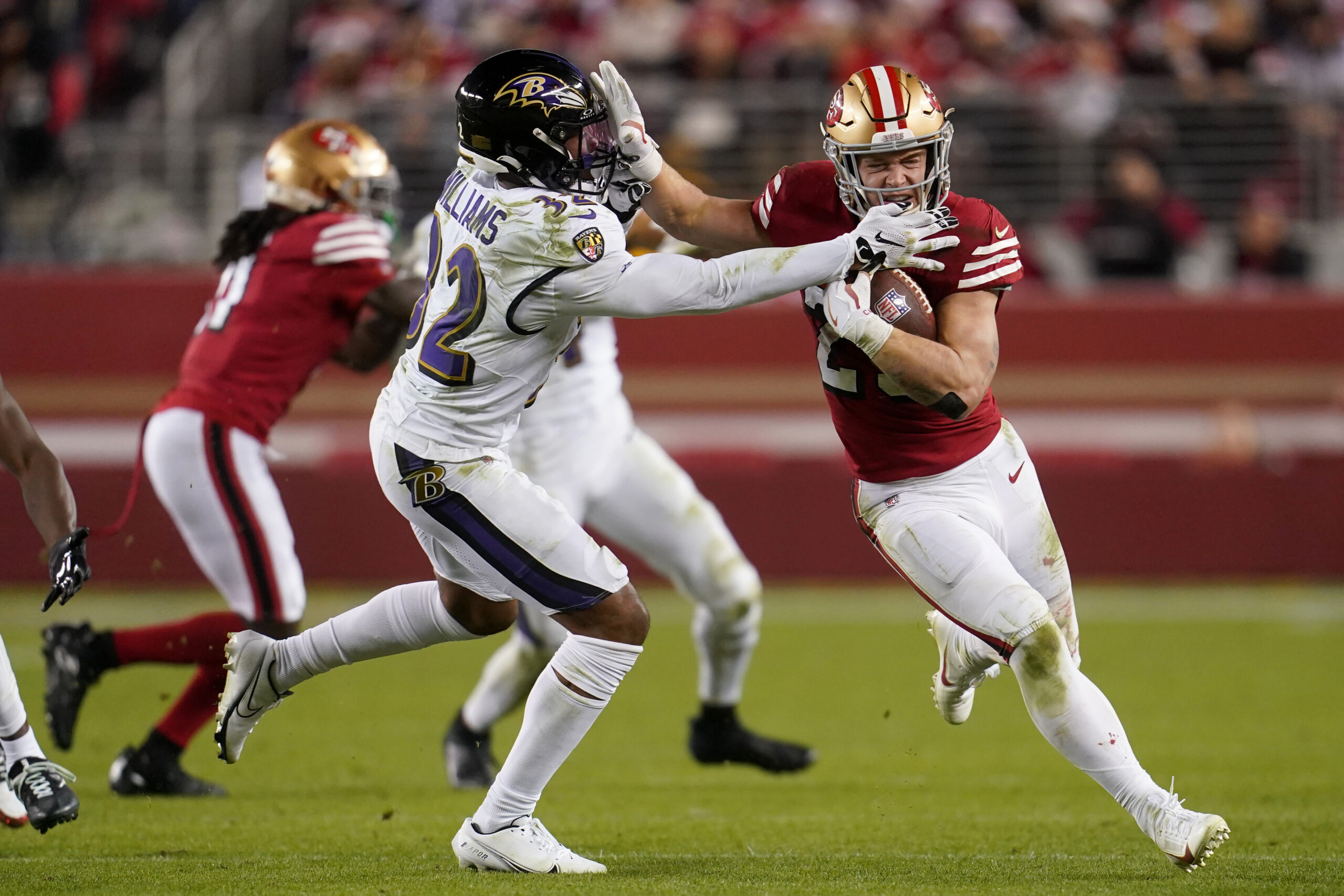 Christian McCaffrey stiff-arms a Ravens defender