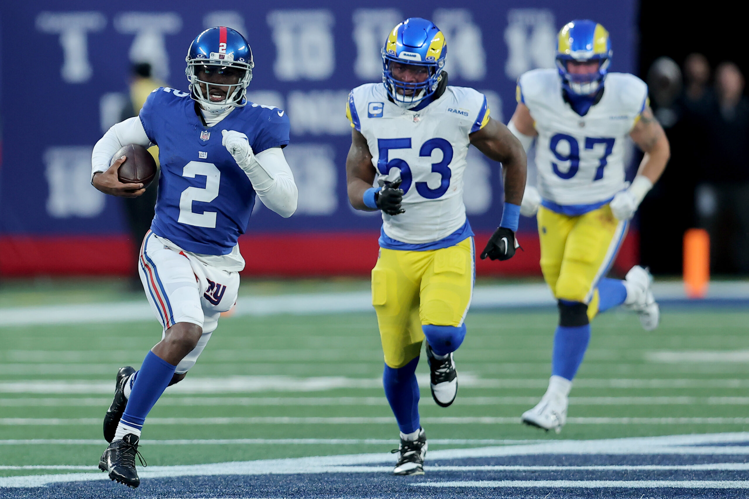 Tyrod Taylor runs with the ball while two players chase after him