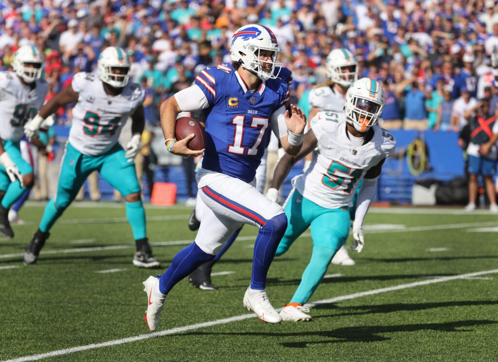 Josh Allen runs the ball with Dolphins defenders in pursuit