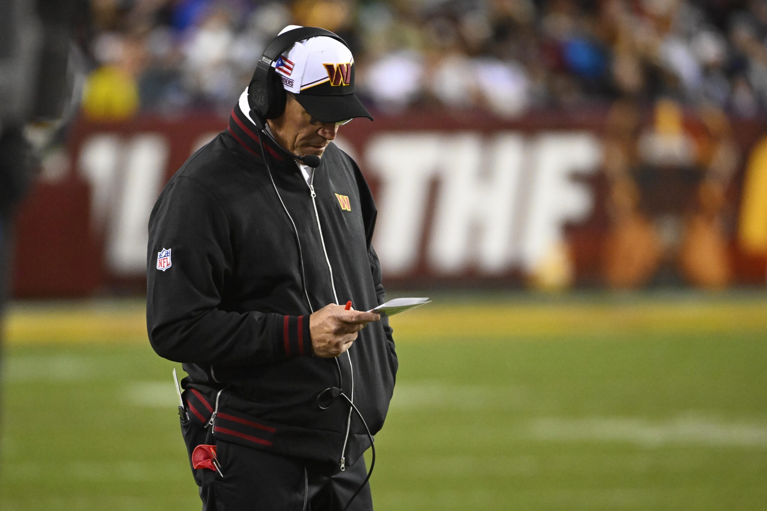 Ron Rivera looks down at play call sheet on the sideline