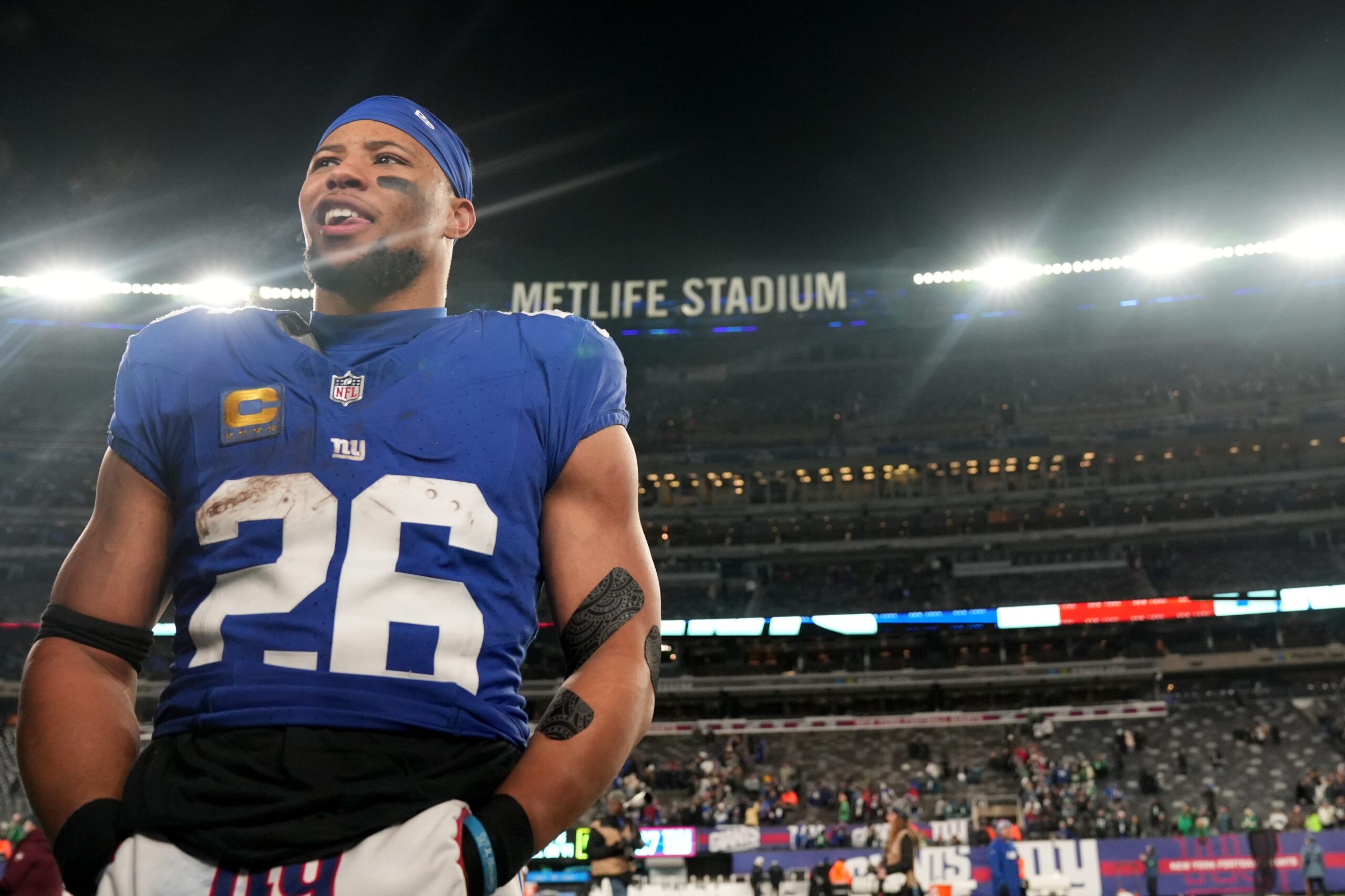 Saquon Barkley on the sideline with no helmet, smiling