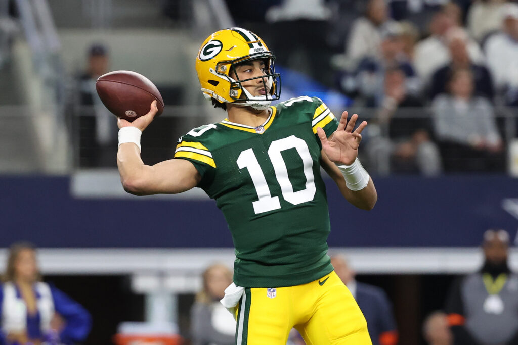 Jordan Love throws a pass (in a green jersey and yellow pants/helmet)