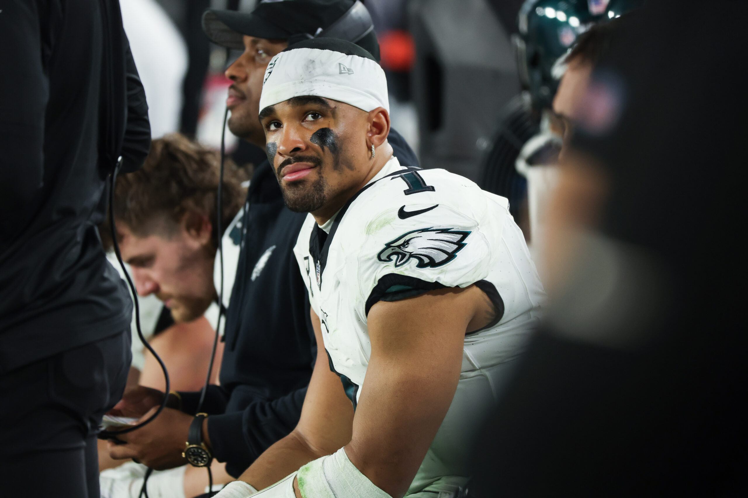 Jalen Hurts sits helmetless on the bench looking distraught