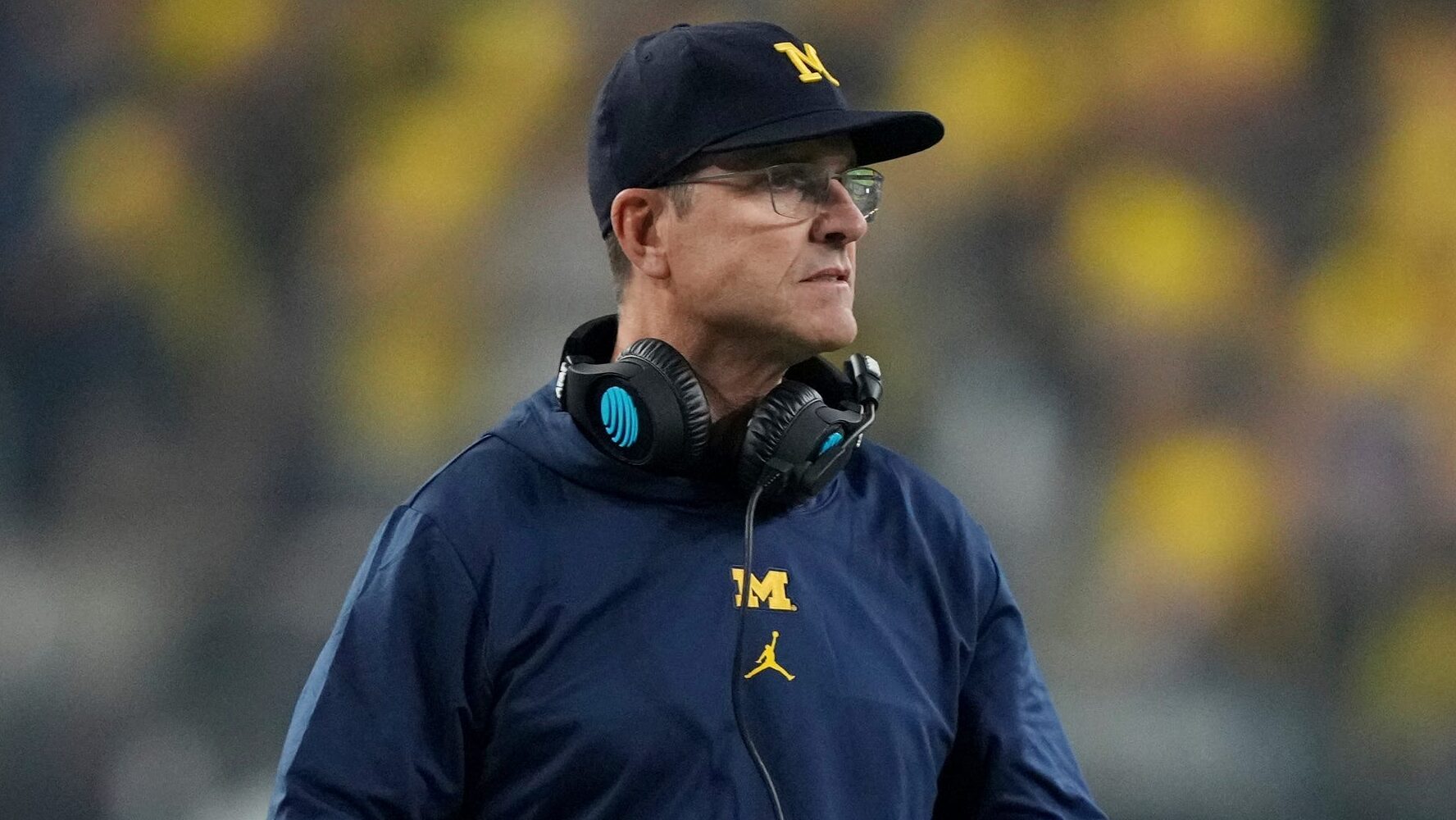 Former Michigan Head Football Coach Jim Harbaugh stands on the sidelines