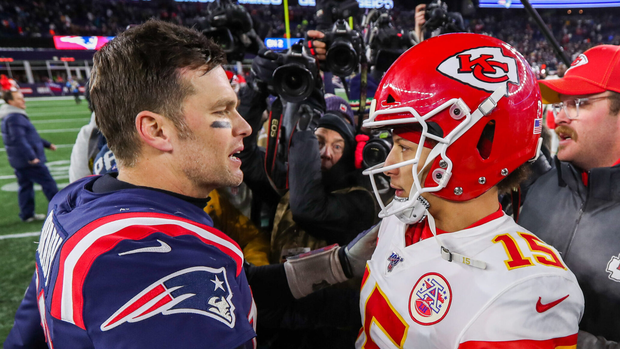 Tom Brady and Patrick Mahomes talk after a game.
