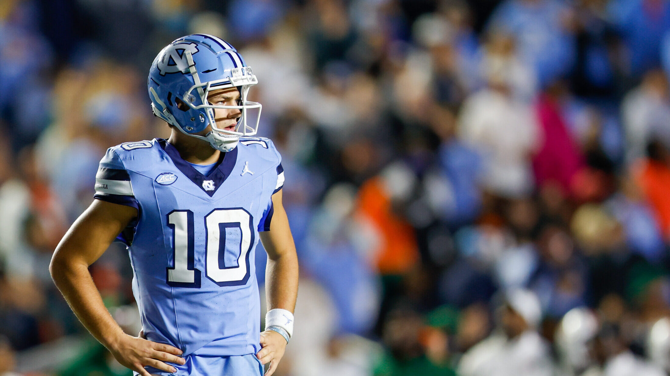 North Carolina QB Drake Maye looks off into the distance with his hands on his hips