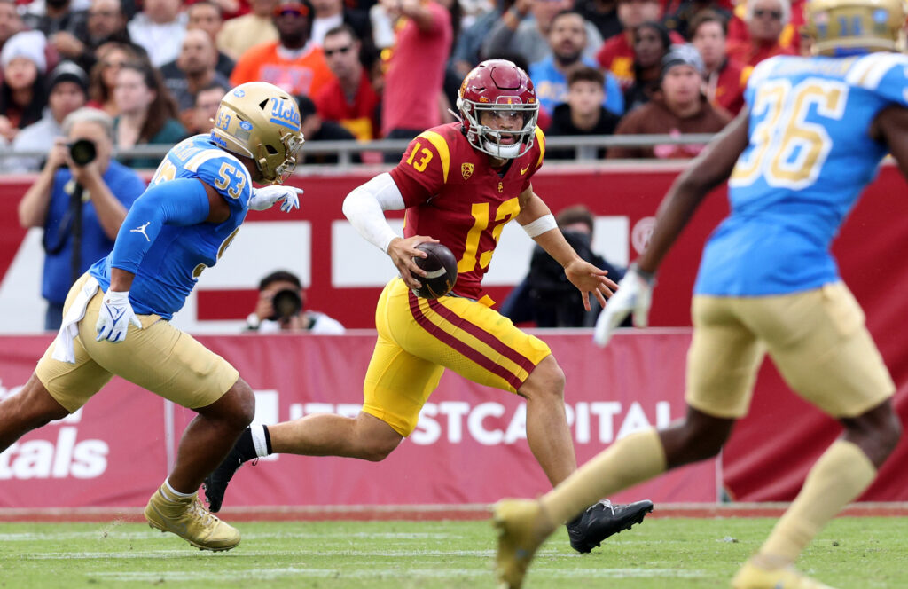 Caleb Williams runs with the ball against UCLA defenders