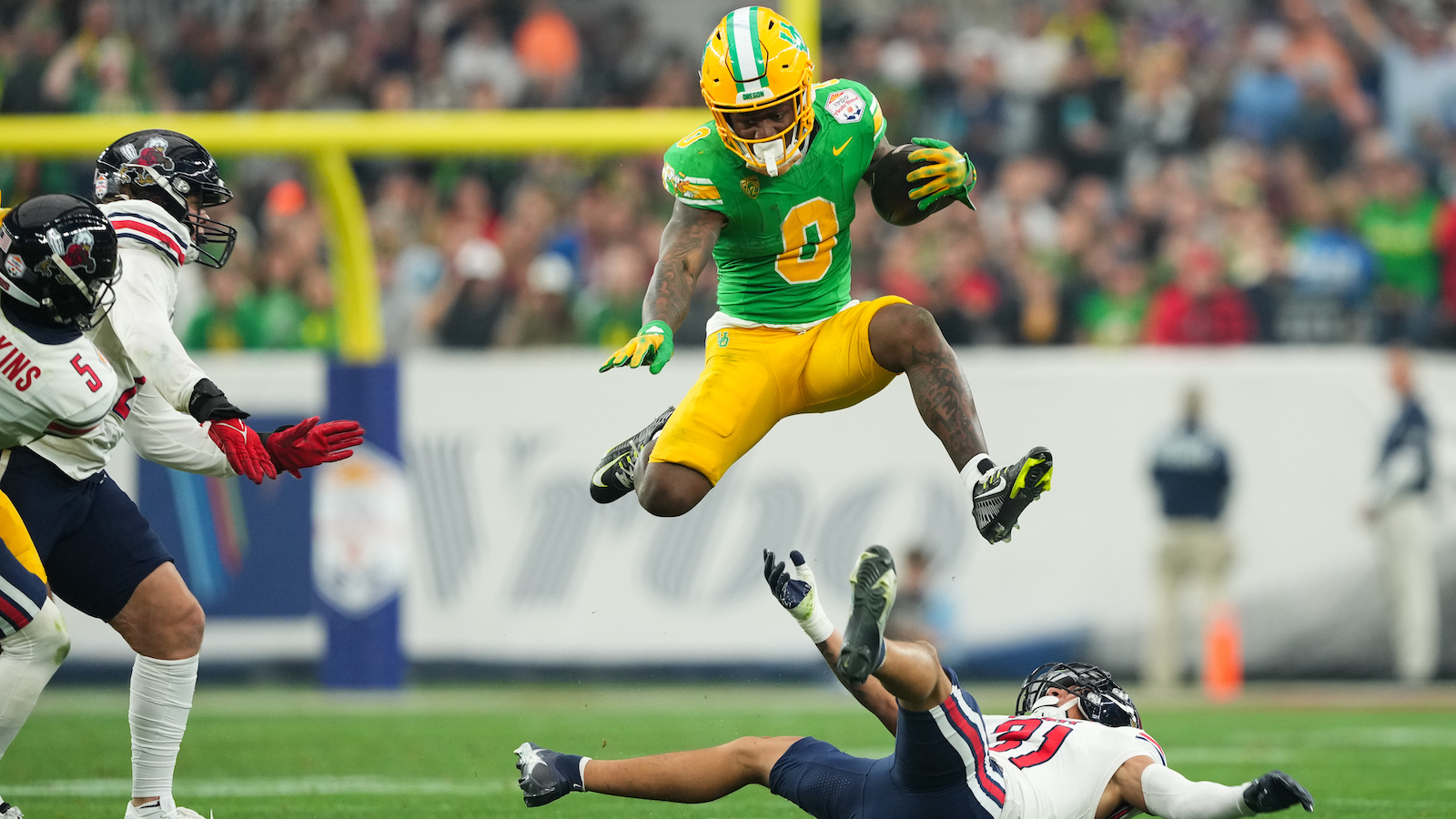 Oregon running back Bucky Irving hurdles a defender