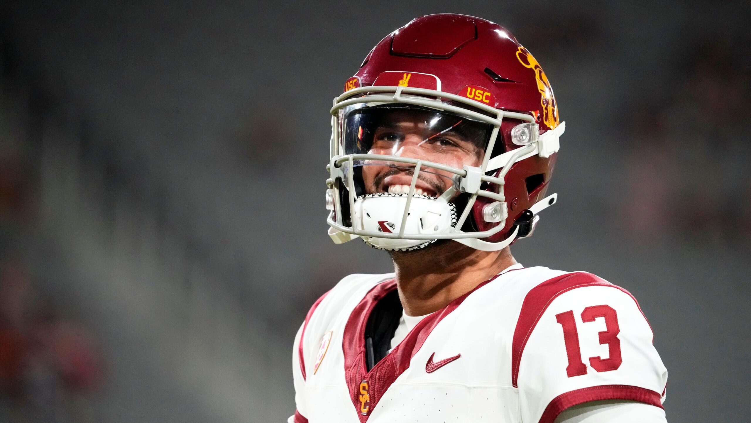 Caleb Williams smiles with his helmet on