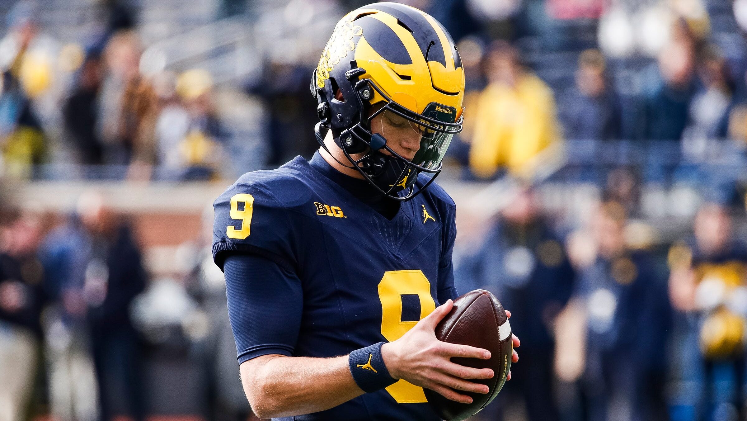 J.J. McCarthy stares at a football in his hands