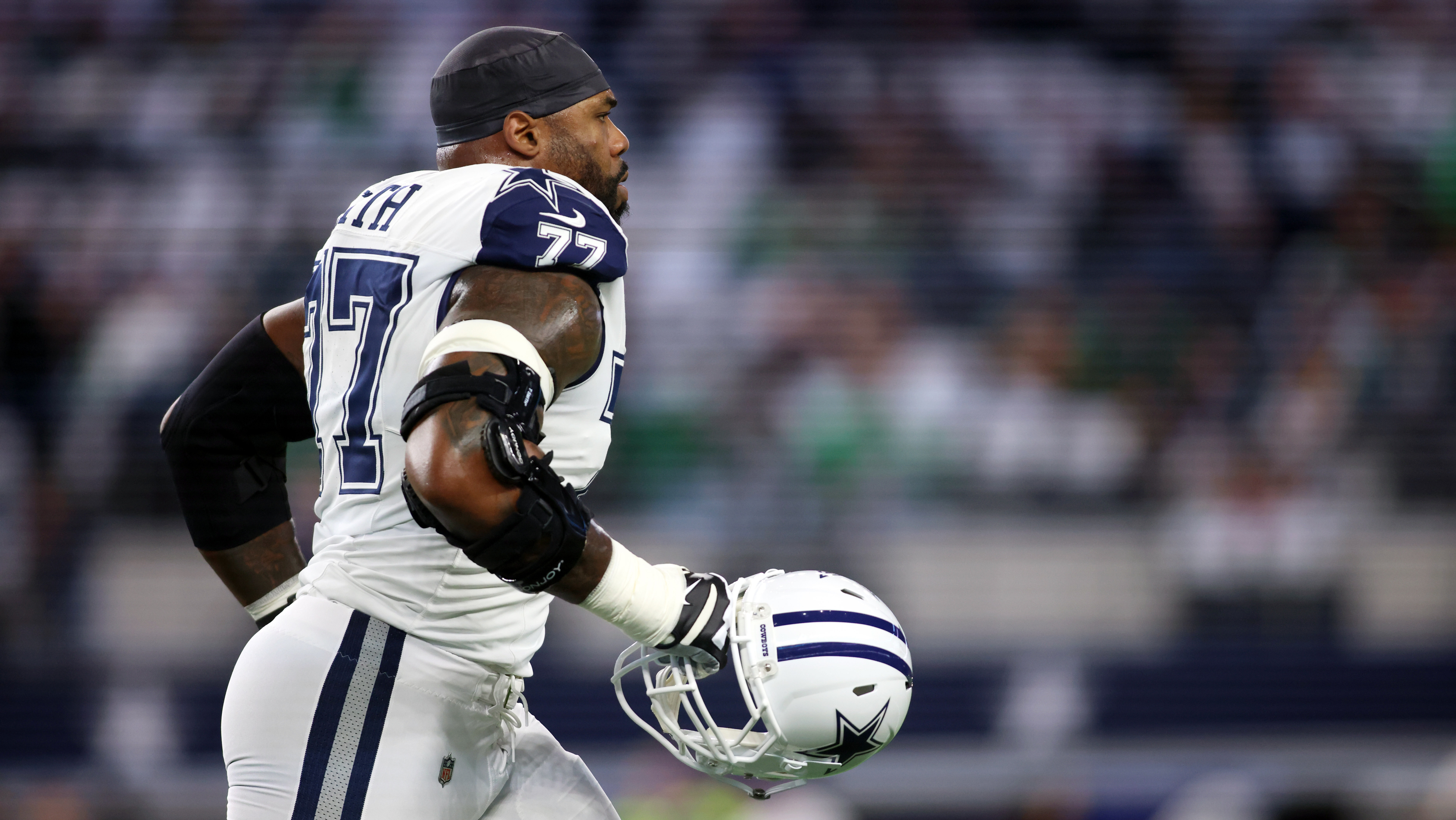 Tyron Smith walks with his helmet off