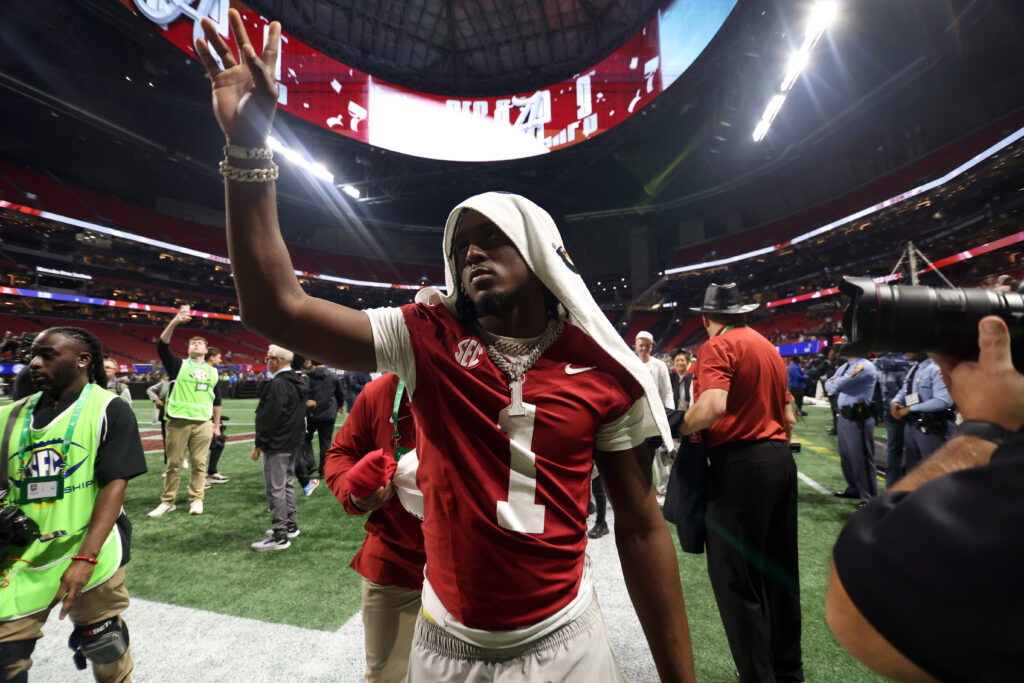 Kool-Aid McKinstry celebrates with fans as he walks off the field with a towel around his head