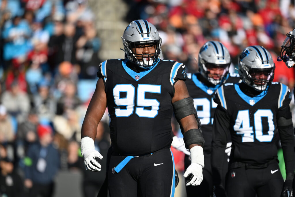 Derrick Brown stands on the field in a black Carolina Panthers uniform