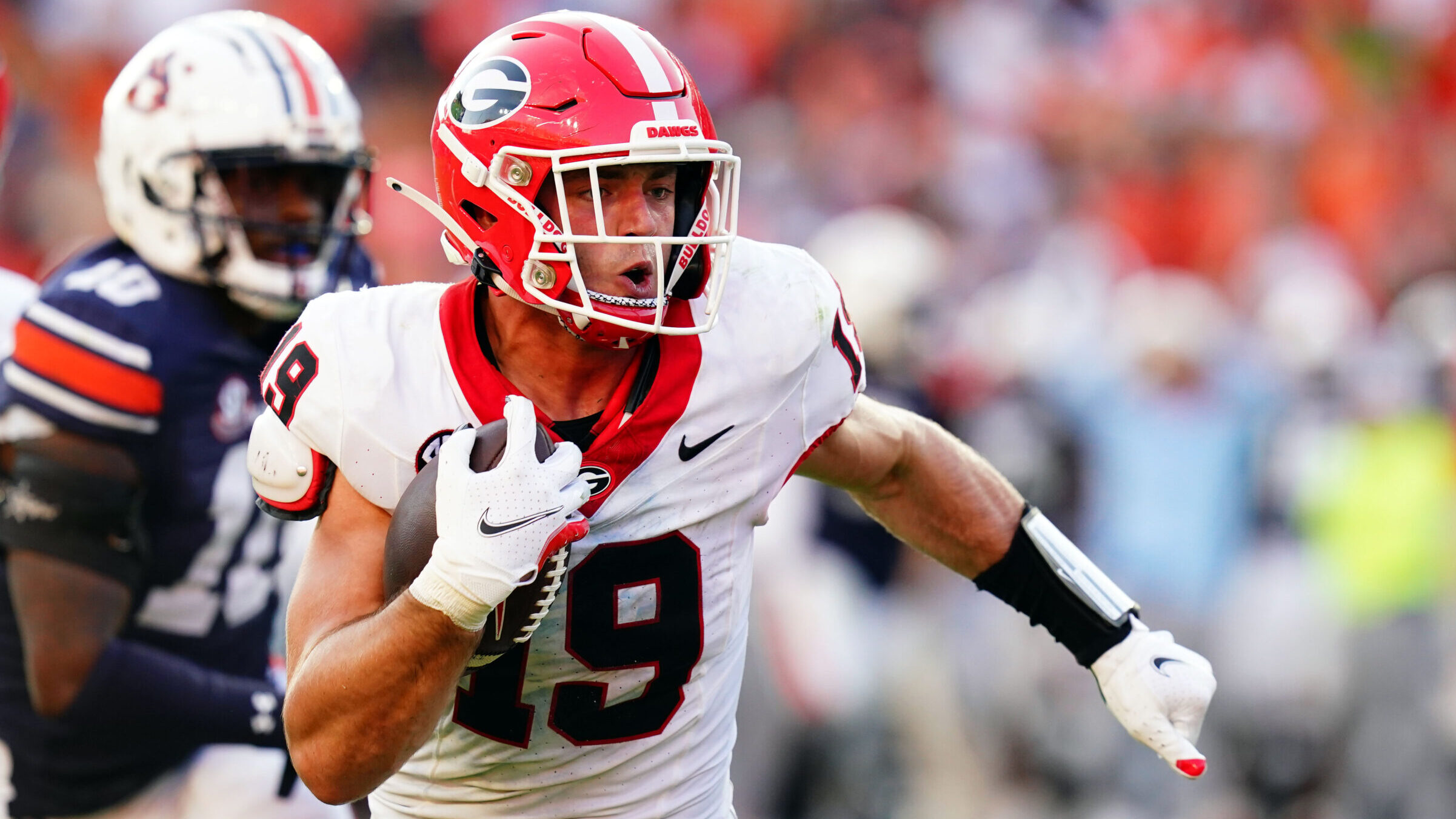 Brock Bowers runs with the football after making a catch.