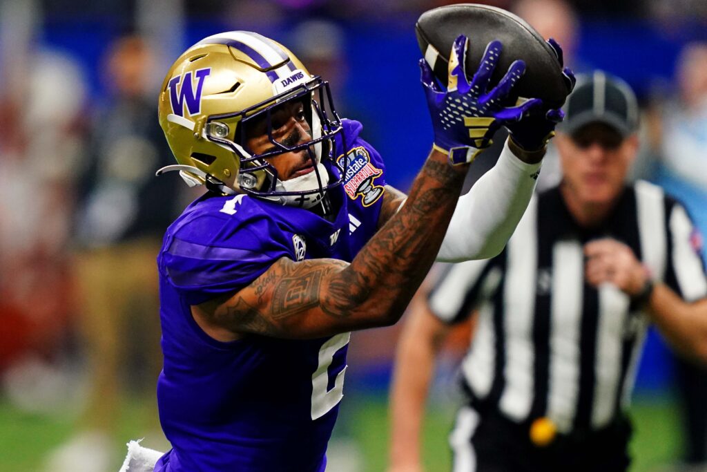 Washington receiver Ja'Lynn Polk catches a pass over his shoulder.