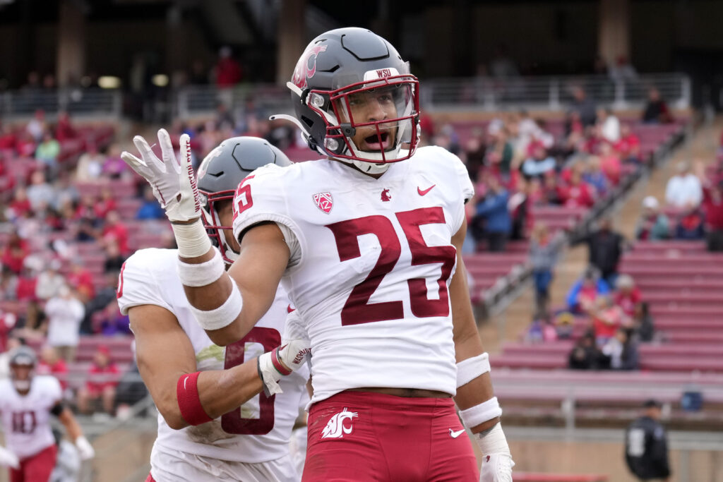 Washington State safety Jaden Hicks motions toward fans after scoring a touchdown