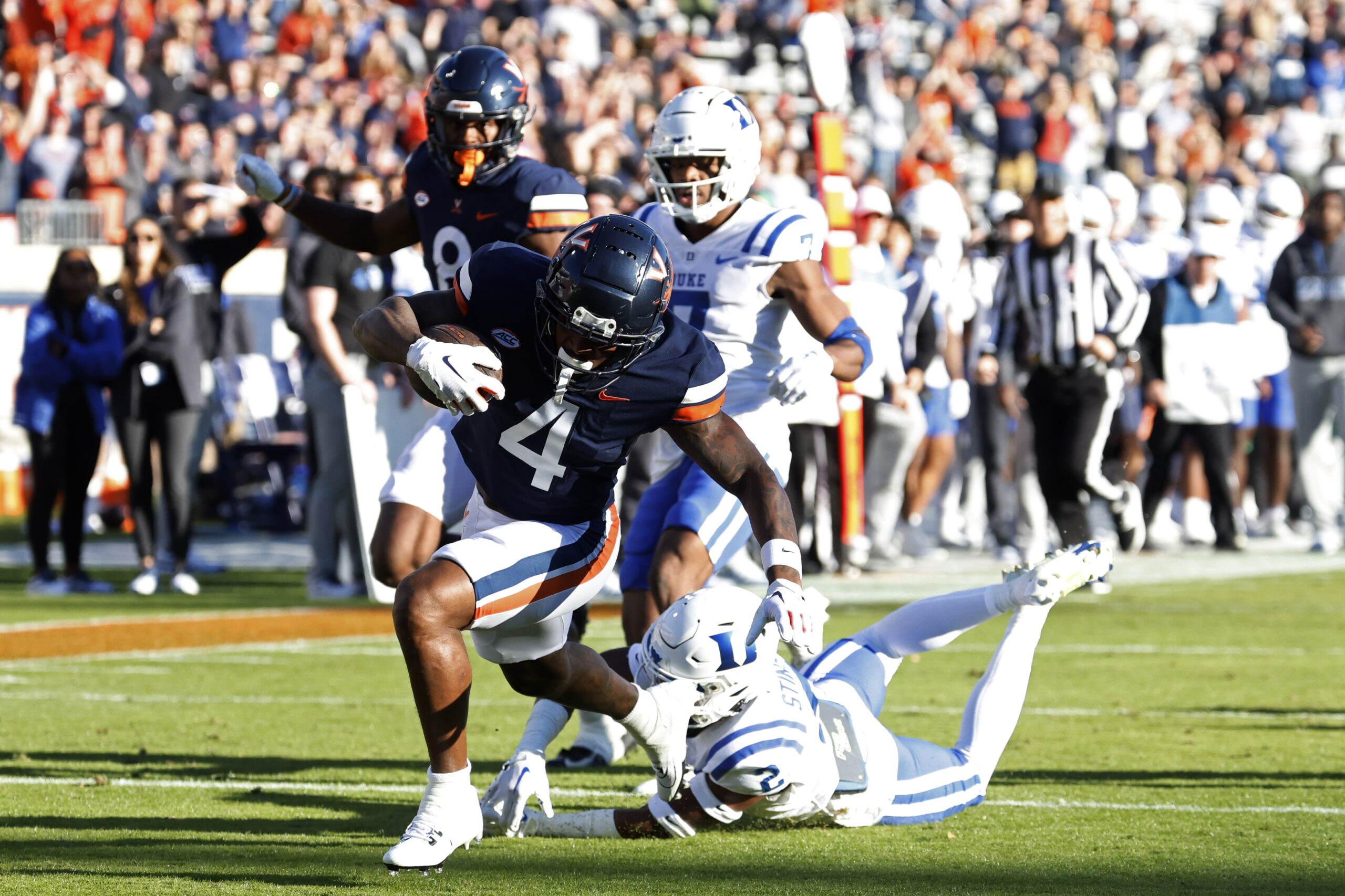 Malik Washington runs toward the goal line with outstretched players trailing behind him