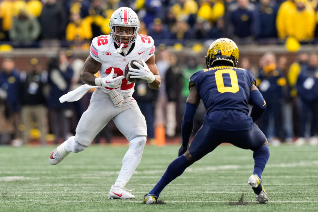 Mike Sainristil, in all blue, looks to tackle an Ohio State wide receiver